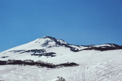 Scenic view of snowcapped mountains against clear blue sky