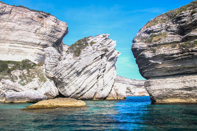 Rock formations in sea against sky