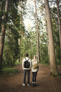 Rear view of couple standing in forest