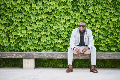 Full length of young man sitting on bench