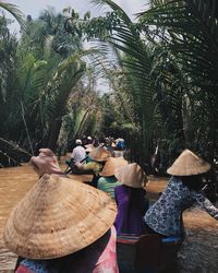 Rear view of people walking on palm trees