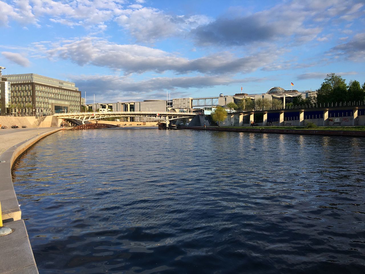 architecture, built structure, building exterior, cloud - sky, water, sky, day, waterfront, outdoors, river, rippled, travel destinations, no people, bridge - man made structure, nature, city, tree