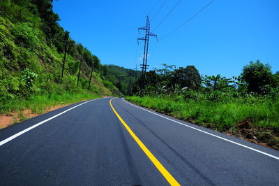 Road amidst trees against clear sky