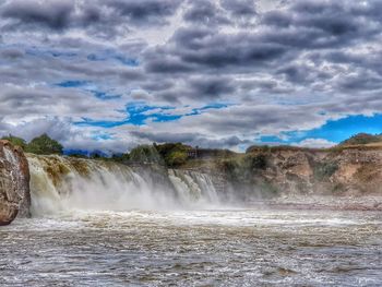 Scenic view of waterfall against sky