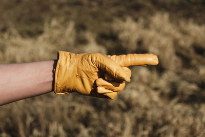 Close-up of hand wearing glove pointing outdoors