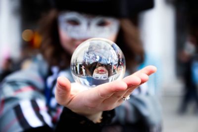 Close-up of hand holding crystal ball with reflection