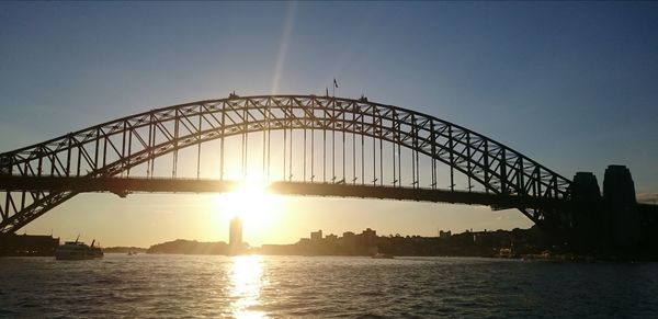 Bridge over river against sky during sunset