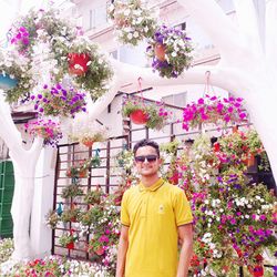 Portrait of woman standing by flowering plants