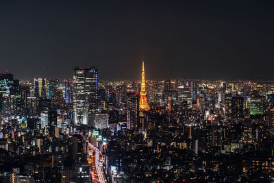 Illuminated cityscape against sky at night
