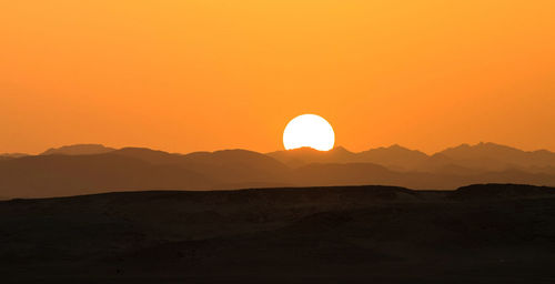 Scenic view of silhouette mountains against sky during sunset