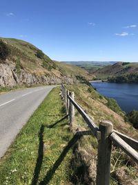 Road by mountain against blue sky