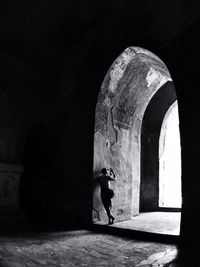 Rear view of woman standing in tunnel