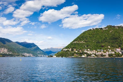 Scenic view of sea by mountains against sky