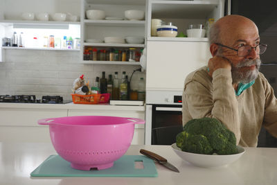 Side view of senior man preparing food at home