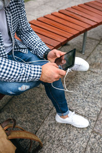 Low section of man using mobile phone