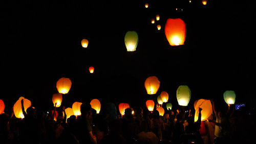 Illuminated lanterns against sky at night