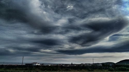 Scenic view of field against cloudy sky