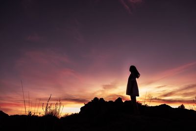 Silhouette woman standing against sky during sunset