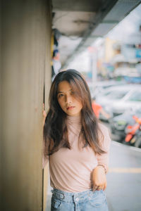 Portrait of young woman standing in city