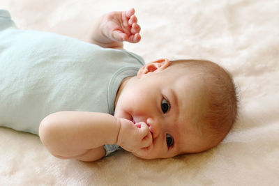 Portrait of cute baby lying on bed