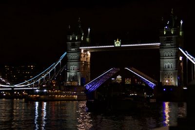 Illuminated bridge over thames river at night