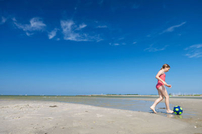 Woman on beach against blue sky