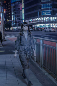 Woman walking on footpath at night