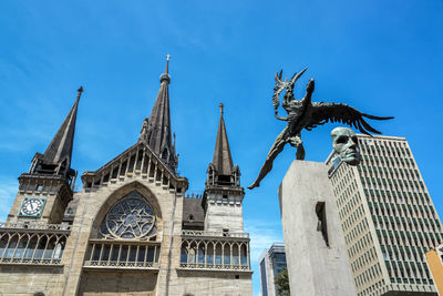 Low angle view of monument and manizales cathedral against sky