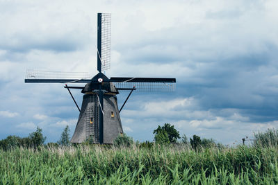 Traditional windmill on field against sky