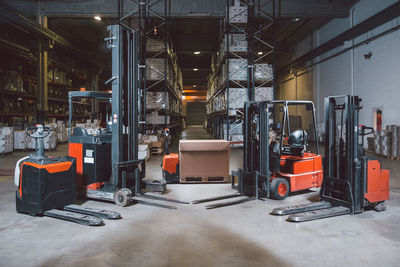 Modern different models of forklift trucks in big warehouse prepared for work day
