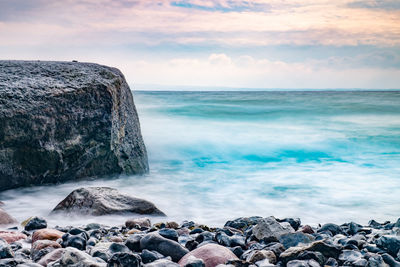 Sunrise over the sea. stone on the foreground. colorful rounded stones on beach