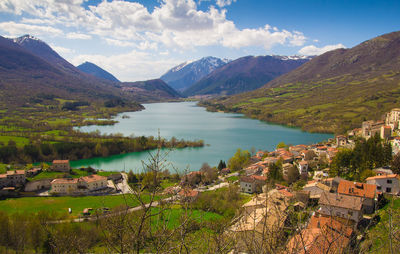 Scenic view of townscape by mountains against sky