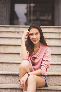 Portrait of young woman sitting on staircase