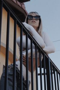 Low angle view of woman standing by railing