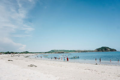 Group of people on beach against sky