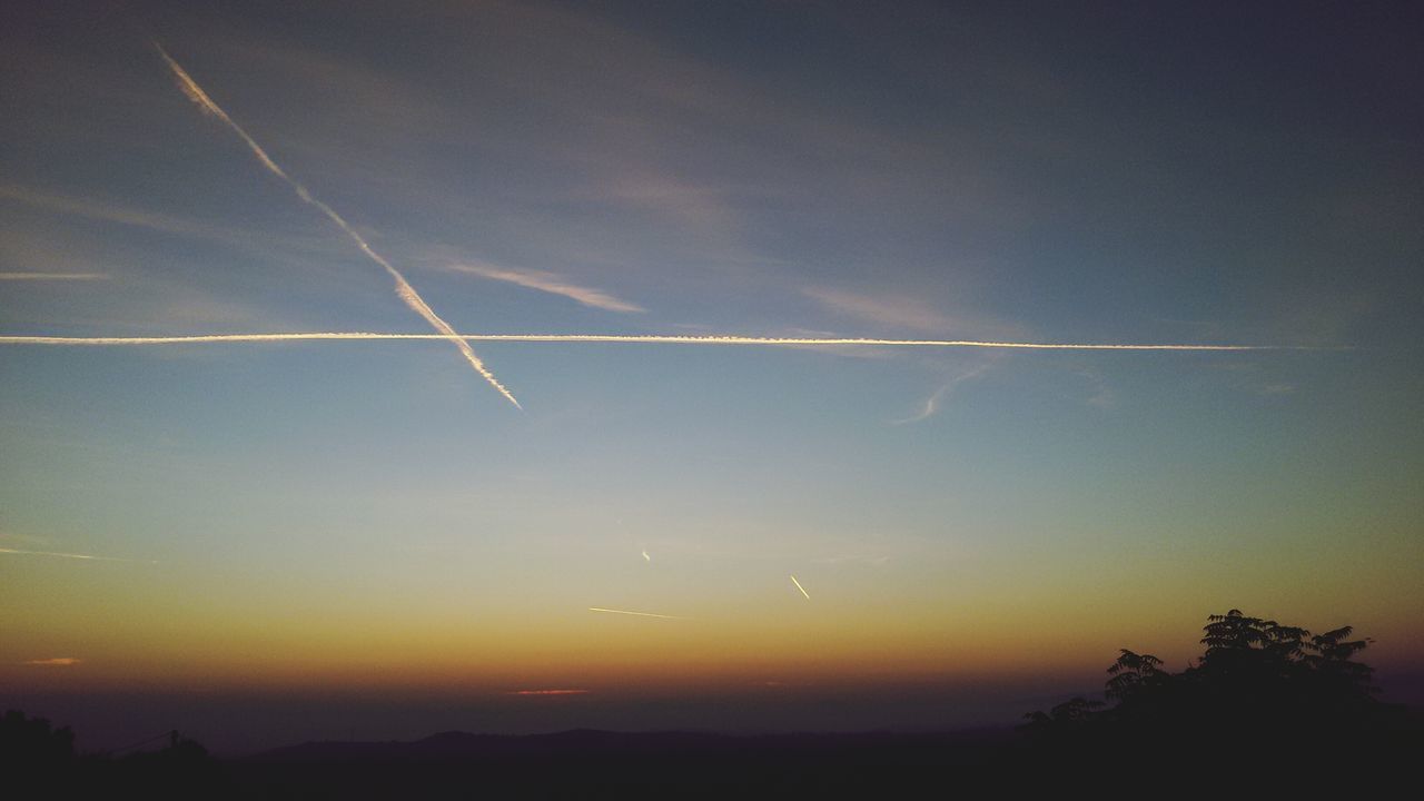 scenics, tranquil scene, beauty in nature, tranquility, sky, sunset, nature, vapor trail, landscape, idyllic, silhouette, flying, outdoors, orange color, no people, majestic, dusk, tree, cloud - sky, non-urban scene