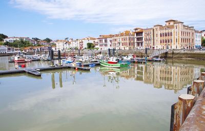 Boats moored in canal against buildings in city