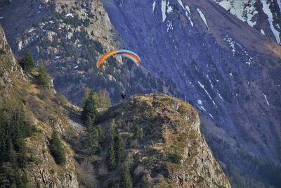 Low angle view of paragliding above mountain