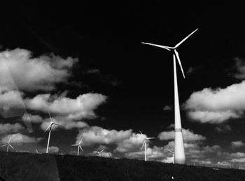 Low angle view of windmill on field against sky