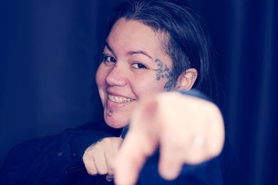 Portrait of smiling young woman holding camera