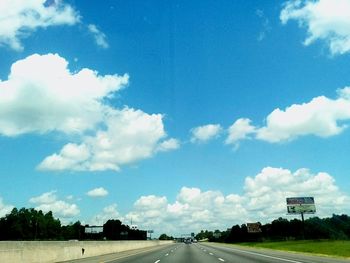Empty road against cloudy sky