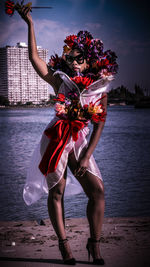 Woman wearing flowers standing at beach