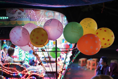 Low angle view of multi colored balloons hanging at market