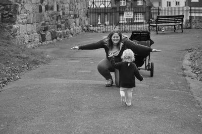 Woman looking at daughter walking on road