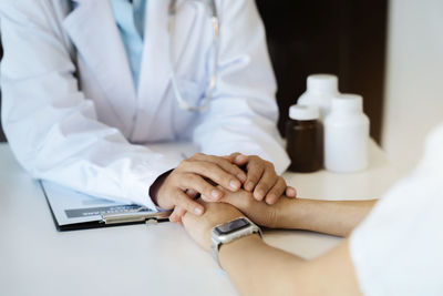 Midsection of doctor examining patient in hospital