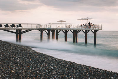 Pier over sea against sky during sunset