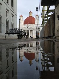 Reflection of buildings on puddle in city