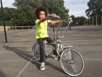 Portrait of boy with bicycle in city