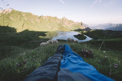 Sleeping bag on grass at bavarian alps against sky