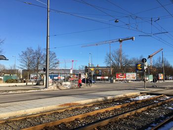 Railroad tracks in city against clear blue sky